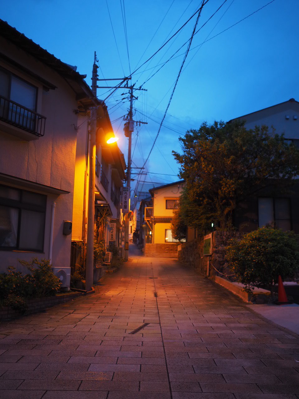 青い夕空と街灯の明かりに包まれる別府の路地