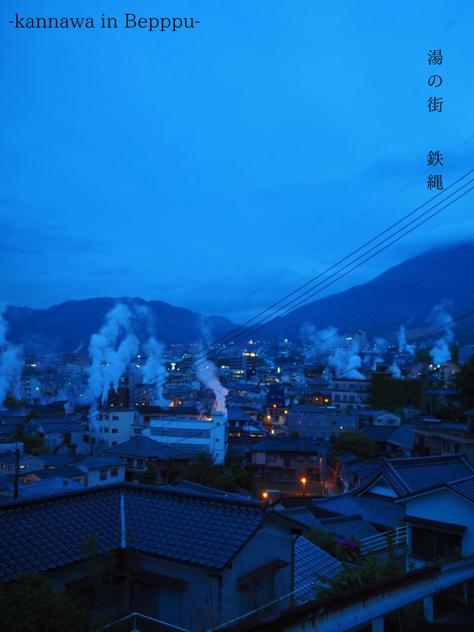 鉄輪のまちに湯けむりが立ちのぼる、青い夕暮れの風景